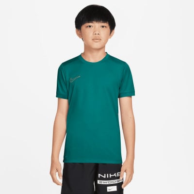 Ein Junge in einem dunkelpetrolfarbenen Nike-T-Shirt und schwarzer Hose mit Logo. Ein Junge in einem dunkelpetrolfarbenen Nike-T-Shirt und schwarzer Hose mit Logo.
