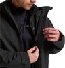 Ein Mann schließt eine schwarze Jacke mit Jack Wolfskin-Logo.