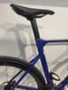 Blaues Rennrad mit schwarzem Sattel und Hinterrad.