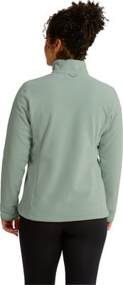 Rückansicht einer Frau in einer grünen Fleecejacke und schwarzen Leggings. Rückansicht einer Frau in einer grünen Fleecejacke und schwarzen Leggings.