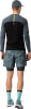 Mann von hinten in dunkelgrauem Langarmshirt und Shorts.