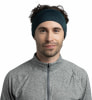 Ein Mann in einem grauen Pullover und einem dunkelblauen Stirnband mit Logo.
