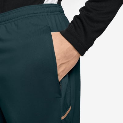 Detail einer dunkelgrünen Sporthose für Herren mit Eingrifftaschen. Detail einer dunkelgrünen Sporthose für Herren mit Eingrifftaschen.