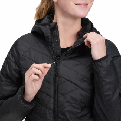 Eine Frau schließt eine schwarze Steppjacke mit einem Reißverschluss. Eine Frau schließt eine schwarze Steppjacke mit einem Reißverschluss.