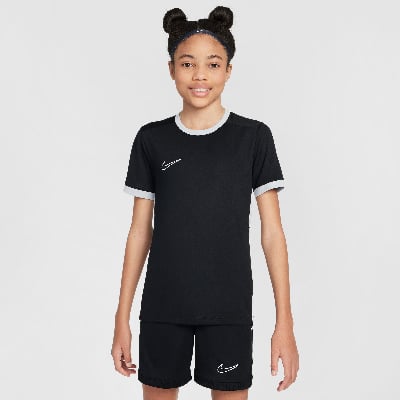 Mädchen in schwarzem Fußballtrikot und Shorts mit Nike-Logo.