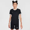 Mädchen in schwarzem Fußballtrikot und Shorts mit Nike-Logo.