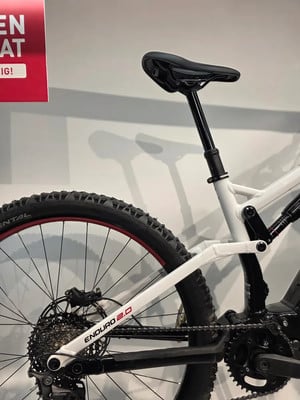 Detail des Hinterrads und des Sattels eines Mountainbikes mit der Aufschrift Enduro 2.0. Detail des Hinterrads und des Sattels eines Mountainbikes mit der Aufschrift Enduro 2.0.