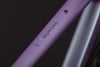 Detail eines violetten Fahrradrahmens mit der Aufschrift NUROAD PRO und der Größe M.