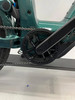Nahaufnahme eines E-Bikes mit Kette und Kurbeln in Dunkelgrün.