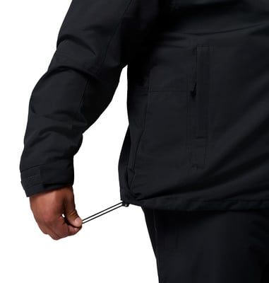 Ein Mann zieht eine schwarze Jacke am Bundkordelzug enger.