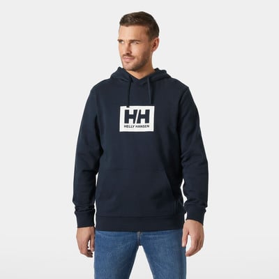 Egy férfi sötétkék pulóverben, Helly Hansen logóval a mellkasán. Egy férfi sötétkék pulóverben, Helly Hansen logóval a mellkasán.
