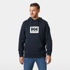 Egy férfi sötétkék pulóverben, Helly Hansen logóval a mellkasán.