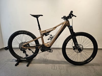 Ein braunes KTM E-Bike mit Federung auf einem Ständer. Ein braunes KTM E-Bike mit Federung auf einem Ständer.