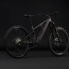 Schwarzes Cube E-Bike mit Federung vor schwarzem Hintergrund.
