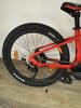 Hinterrad eines roten Mountain-E-Bikes mit Kette und Schaltwerk.