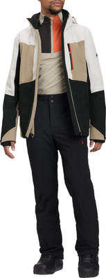 Ein Mann in einer Winterjacke und Hose mit farbigen Einsätzen und orangefarbenem Detail.