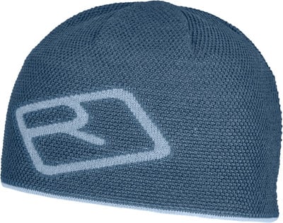 Eine blaue Strickmütze mit Logo an der Seite. Eine blaue Strickmütze mit Logo an der Seite.