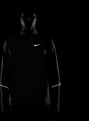 Mann in schwarzem Nike-Shirt mit reflektierenden Details an den Ärmeln. Mann in schwarzem Nike-Shirt mit reflektierenden Details an den Ärmeln.