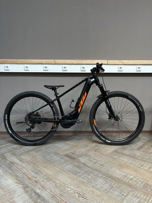 Schwarzes E-Bike mit orangefarbenen Details vor dunklem Hintergrund. Schwarzes E-Bike mit orangefarbenen Details vor dunklem Hintergrund.