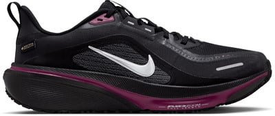 Schwarzer Nike Laufschuh mit weißem Swoosh und violetten Akzenten. Schwarzer Nike Laufschuh mit weißem Swoosh und violetten Akzenten.