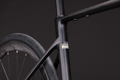 Rahmendetail eines schwarzen Fahrrads mit UCI-Logo und Aufkleber Rahmendetail eines schwarzen Fahrrads mit UCI-Logo und Aufkleber