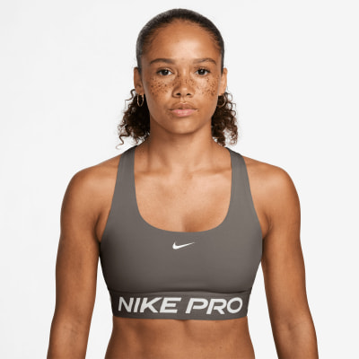 Frau in einem dunkelgrauen Nike Pro Sport-BH mit Logo.