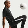 Ein Mann im schwarzen Nike-Shirt jongliert mit einem weißen Ball.