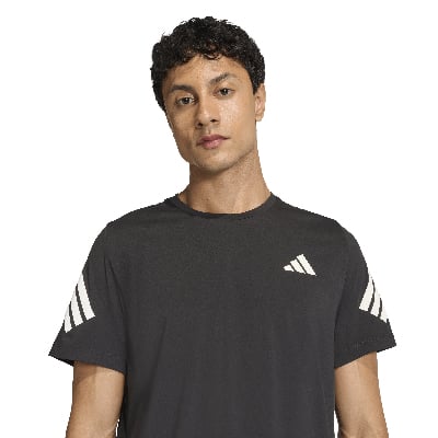 Egy férfi fekete pólóban, Adidas logóval a mellkasán és az ujjain. Egy férfi fekete pólóban, Adidas logóval a mellkasán és az ujjain.