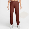 Braune Jogginghose für Damen mit Nike-Logo und weißen Sneakern.