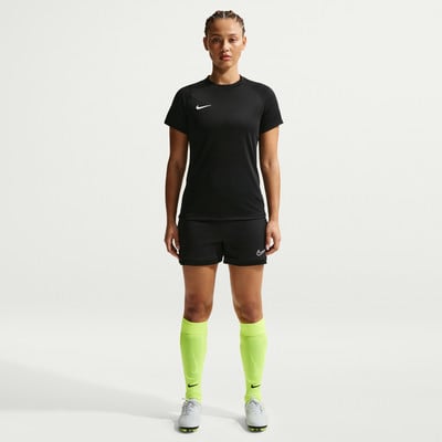 Eine Frau in Nike-Fußballkleidung steht vor einem weißen Hintergrund.