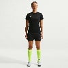 Eine Frau in Nike-Fußballkleidung steht vor einem weißen Hintergrund.