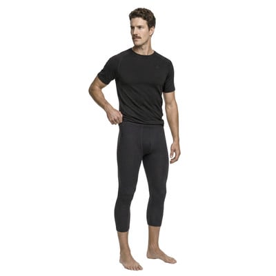 Ein Mann in einem dunklen T-Shirt und 3/4-langen Leggings steht vor weißem Hintergrund. Ein Mann in einem dunklen T-Shirt und 3/4-langen Leggings steht vor weißem Hintergrund.