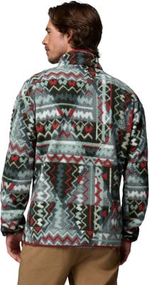 Ein Mann von hinten in einer bunten Fleecejacke mit geometrischem Muster. Ein Mann von hinten in einer bunten Fleecejacke mit geometrischem Muster.