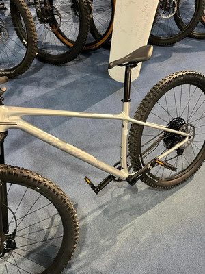 Ein silbernes Mountainbike mit schwarzem Sattel und schwarzen Pedalen auf blauem Untergrund. Ein silbernes Mountainbike mit schwarzem Sattel und schwarzen Pedalen auf blauem Untergrund.