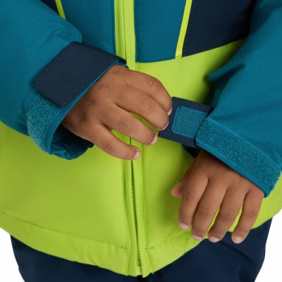 Kinderhände schließen den Klettverschluss am Ärmel der Jacke. Kinderhände schließen den Klettverschluss am Ärmel der Jacke.