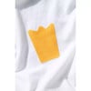 Gelber Aufnäher in Kronenform auf weißem T-Shirt.