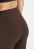 Detail des Pos einer Frau in brauner Leggings mit Markenlogo.