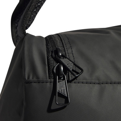 Detail eines Reißverschlusses mit Adidas-Logo auf einem schwarzen Rucksack. Detail eines Reißverschlusses mit Adidas-Logo auf einem schwarzen Rucksack.