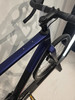 Detail des Rahmens eines violetten Gravelbikes mit Lenker und Vorderrad.