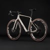 Beiges Cube Gravelbike mit schwarzen Zipp Carbonfelgen vor schwarzem Hintergrund.