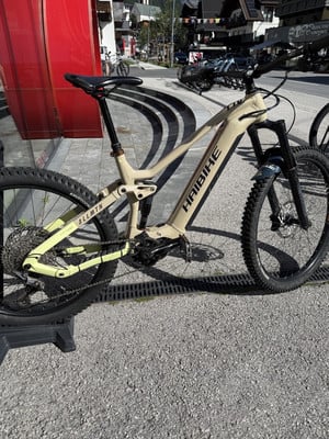 Ein Haibike Mountain E-Bike steht auf dem Bürgersteig vor einem Gebäude mit roter Fassade.