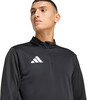 Ein Mann in einem schwarzen Oberteil mit Adidas-Logo.