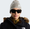 Eine Frau in einer Winterjacke, Mütze und Sonnenbrille mit The North Face Logo.