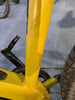 Gelber Fahrradrahmen mit Kette und Pedal auf blauem Teppich.