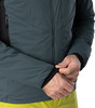 Ein Mann passt den Ärmel einer dunkelgrauen Isolationsjacke mit schwarzem Bündchen an.