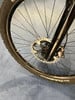 Detail eines Mountainbike-Vorderrads mit Scheibenbremse und Reifen.