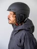 Ein Mann in schwarzer Skibekleidung und Helm mit Alpina-Aufschrift.