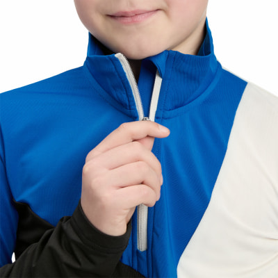 Ein Kind schließt eine blau-schwarze Jacke mit einem weißen Streifen. Ein Kind schließt eine blau-schwarze Jacke mit einem weißen Streifen.