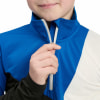 Ein Kind schließt eine blau-schwarze Jacke mit einem weißen Streifen.
