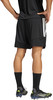 Ein Mann in schwarzen Shorts und Fußballschuhen mit weißen Streifen am Bein.